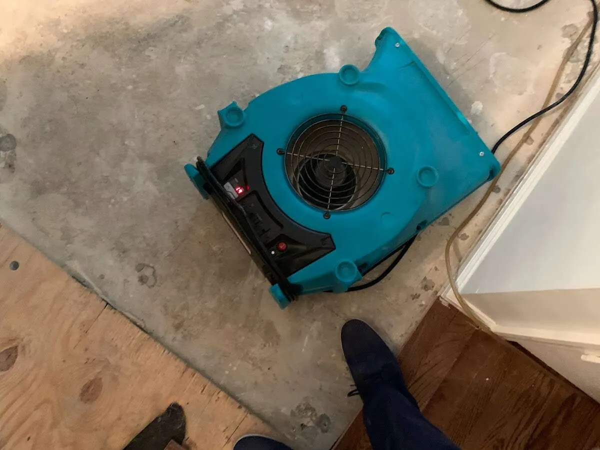 Air mover drying subfloor during Commercial Water Damage Restoration in Fort Carson
